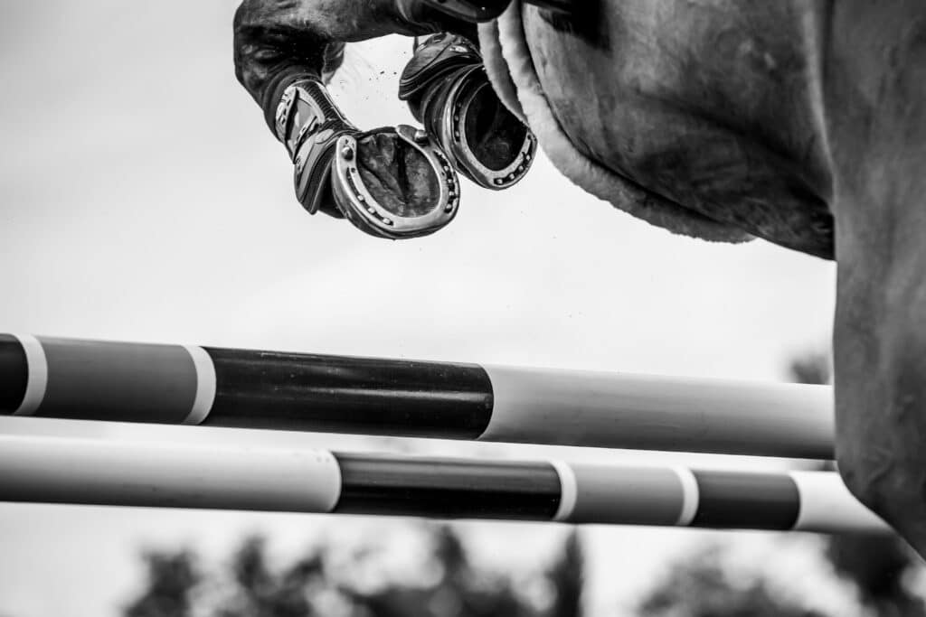 Close-up of a horse's hooves mid-air during a show jump